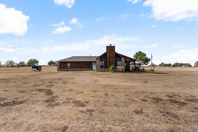 rear view of property featuring a rural view and an outbuilding