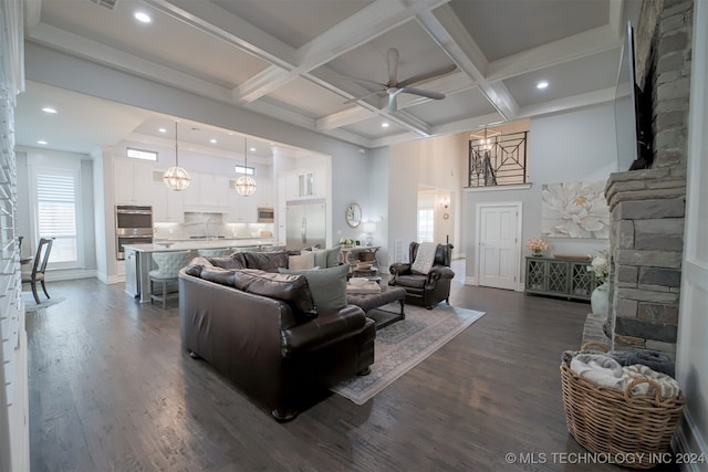 living room featuring coffered ceiling, beam ceiling, dark wood-type flooring, and ceiling fan