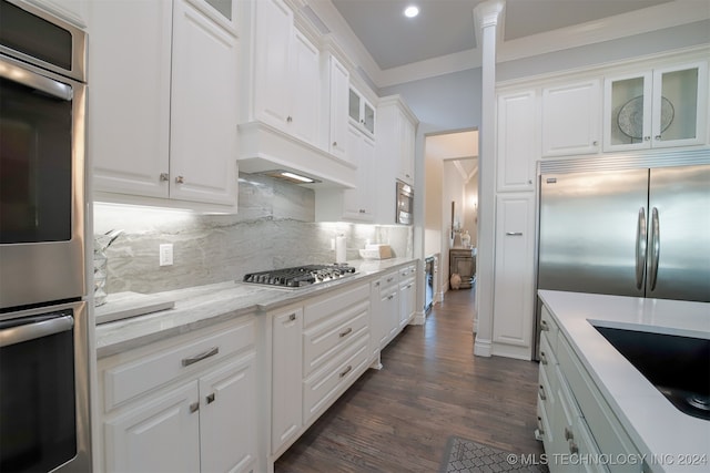 kitchen featuring built in appliances and white cabinetry