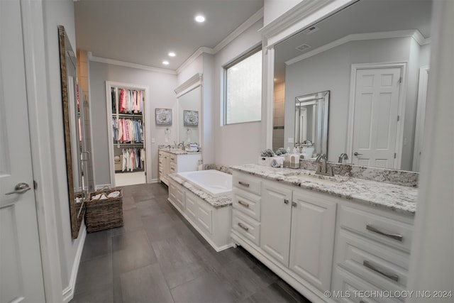 bathroom with ornamental molding, a tub to relax in, and vanity