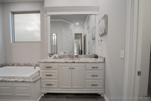 bathroom with crown molding, a washtub, and vanity