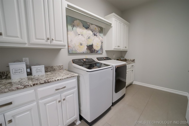 laundry room featuring light tile patterned floors, cabinets, and independent washer and dryer