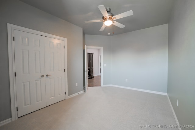 unfurnished bedroom with carpet floors, a closet, and ceiling fan