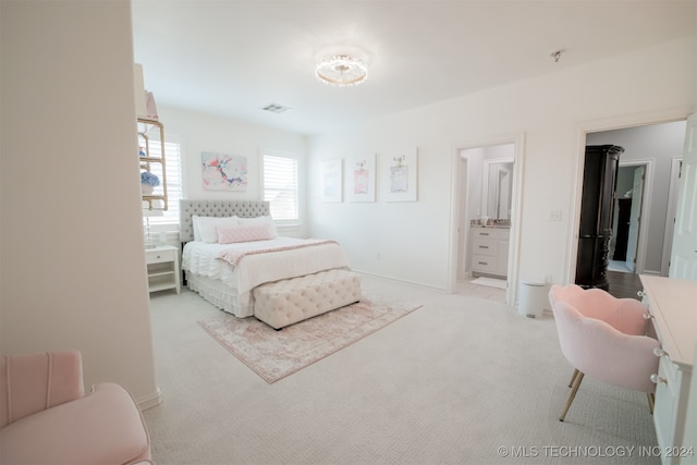 bedroom with light carpet and connected bathroom