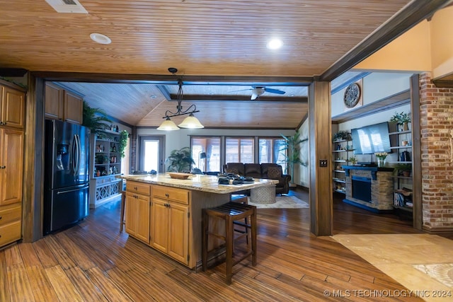 kitchen with wooden ceiling, black fridge with ice dispenser, dark hardwood / wood-style flooring, light stone countertops, and a kitchen bar