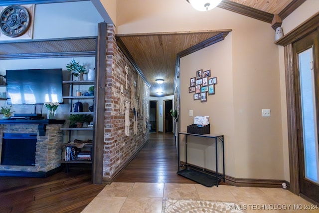 hall with ornamental molding, wood ceiling, hardwood / wood-style floors, and brick wall