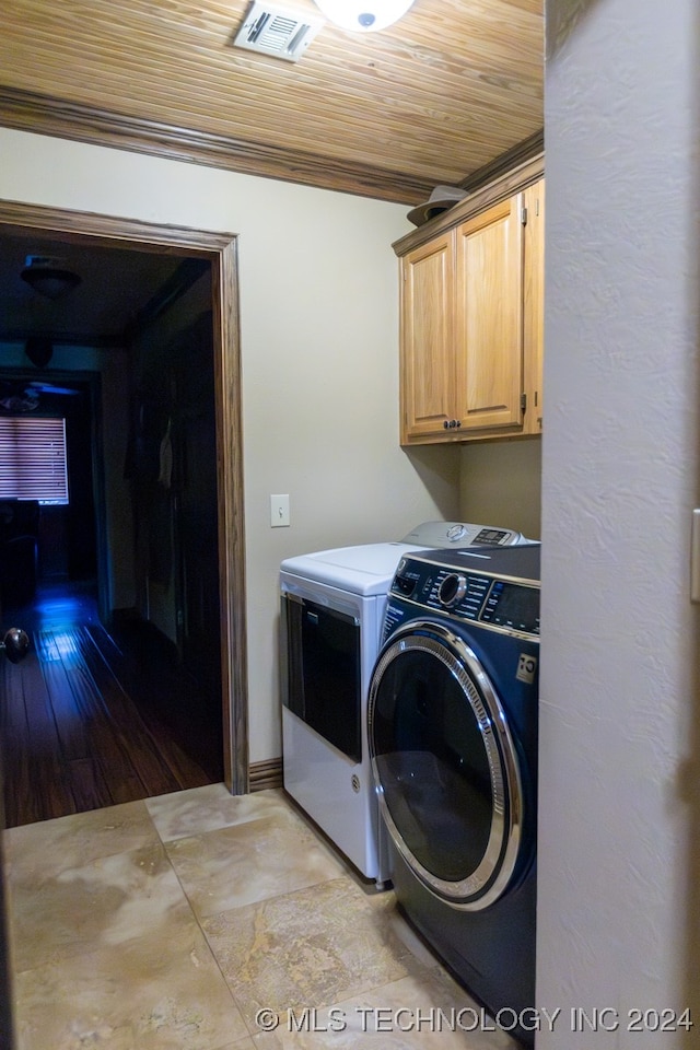 clothes washing area with ornamental molding, cabinets, wooden ceiling, separate washer and dryer, and light wood-type flooring