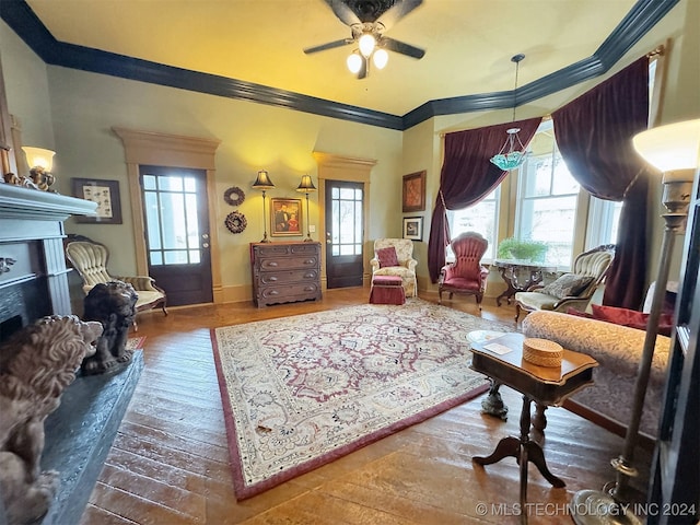 sitting room with crown molding, dark hardwood / wood-style flooring, and ceiling fan