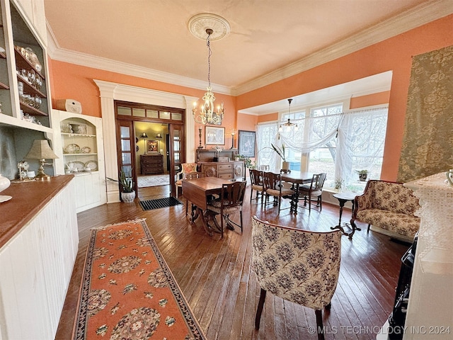 dining space featuring dark wood-type flooring, ornamental molding, and an inviting chandelier