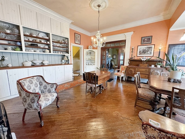 dining space featuring an inviting chandelier, crown molding, and hardwood / wood-style floors