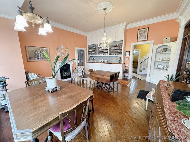 dining space with a chandelier, crown molding, and dark hardwood / wood-style flooring