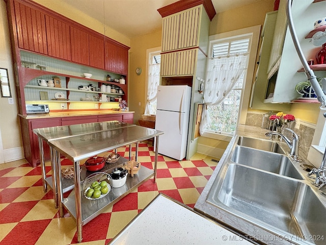 kitchen with stainless steel counters, sink, and white fridge