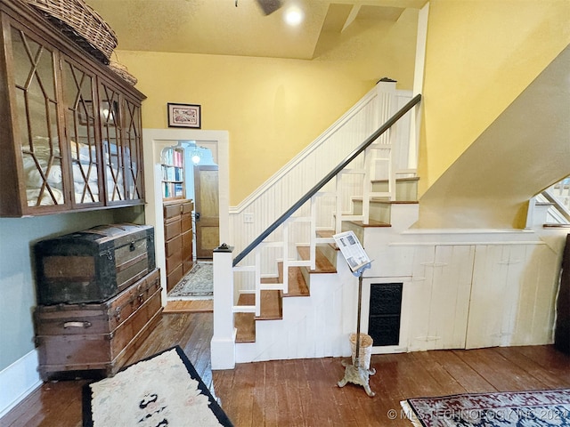 stairs with hardwood / wood-style flooring and ceiling fan