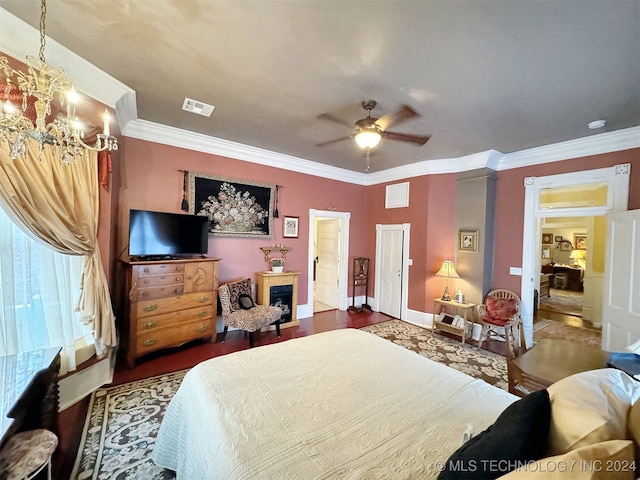 bedroom featuring ceiling fan with notable chandelier, crown molding, and dark hardwood / wood-style flooring