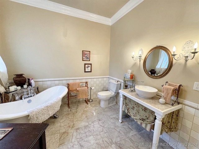 bathroom featuring tile walls, ornamental molding, a washtub, and toilet