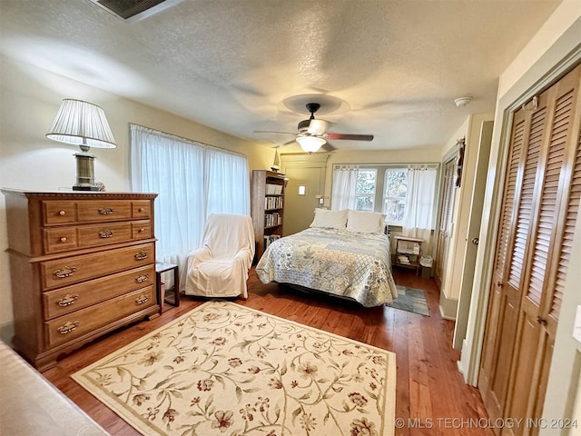 bedroom featuring ceiling fan, a textured ceiling, a closet, and dark hardwood / wood-style floors