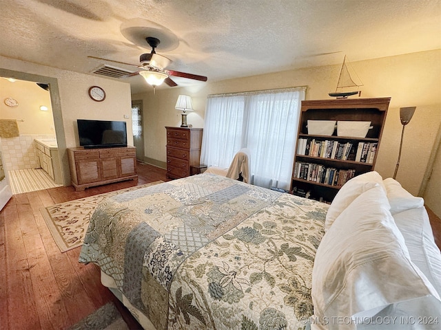 bedroom with ceiling fan, hardwood / wood-style flooring, and a textured ceiling