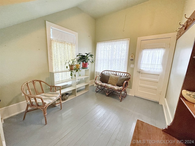 living area with wood-type flooring and vaulted ceiling