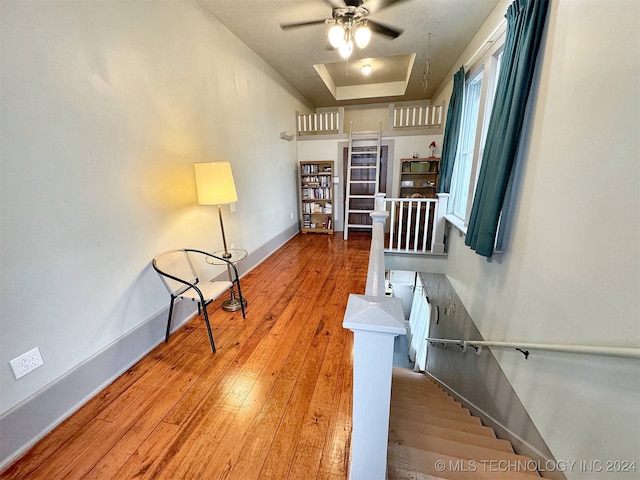 stairway featuring wood-type flooring and ceiling fan