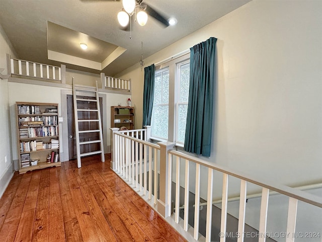 hall with a tray ceiling and hardwood / wood-style flooring