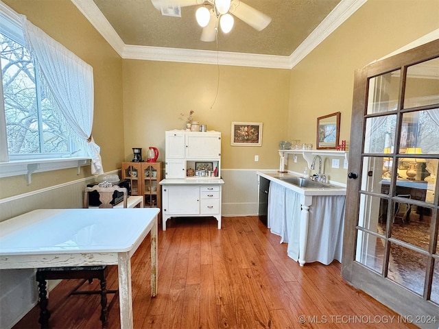 kitchen with a healthy amount of sunlight, sink, light hardwood / wood-style floors, and white cabinets