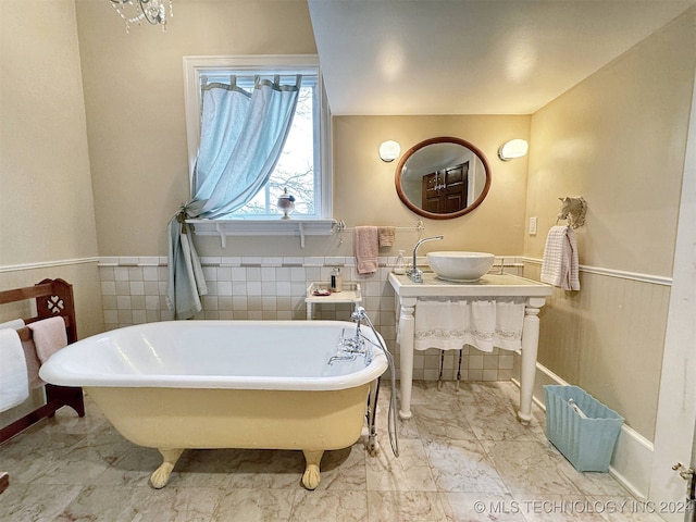 bathroom with vanity, a bathtub, and tile walls