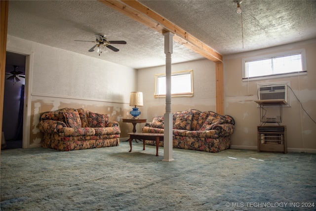 living room featuring beamed ceiling, a wealth of natural light, a wall unit AC, and a textured ceiling