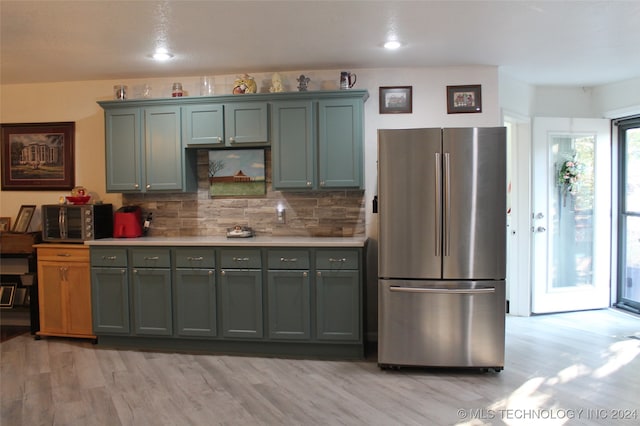 kitchen featuring light hardwood / wood-style floors, decorative backsplash, and stainless steel appliances