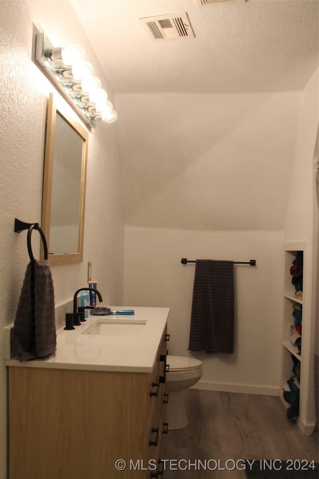 bathroom with hardwood / wood-style flooring, vanity, and toilet