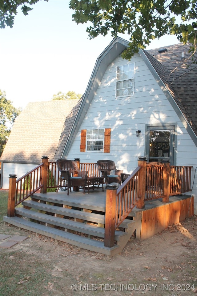 rear view of property featuring a deck