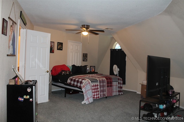 bedroom featuring ceiling fan, a textured ceiling, dark colored carpet, and vaulted ceiling