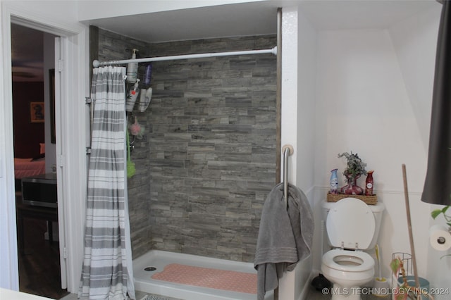 bathroom with curtained shower and toilet