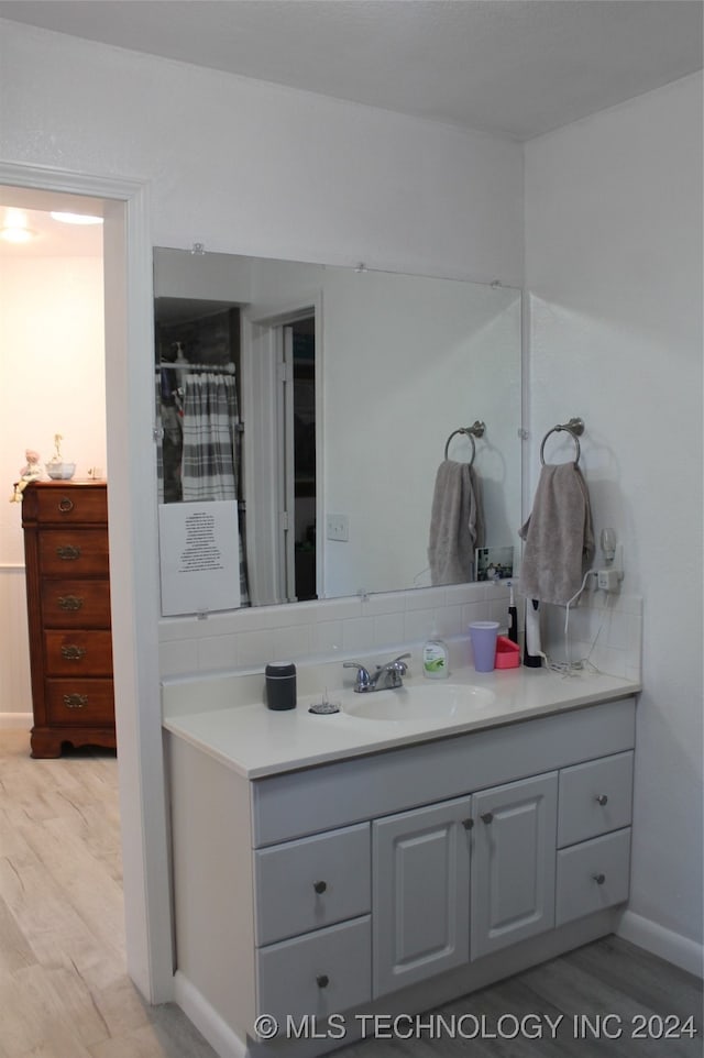 bathroom with vanity, backsplash, and hardwood / wood-style flooring