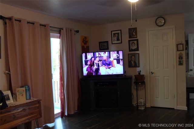 living room with ceiling fan and dark wood-type flooring