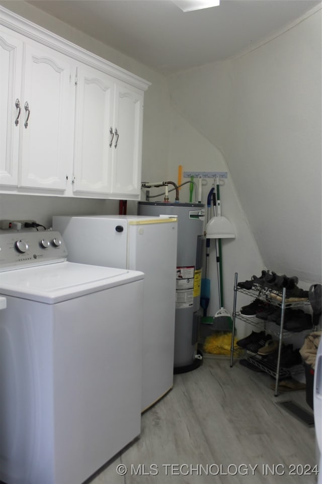 washroom featuring light wood-type flooring, washer / dryer, water heater, and cabinets