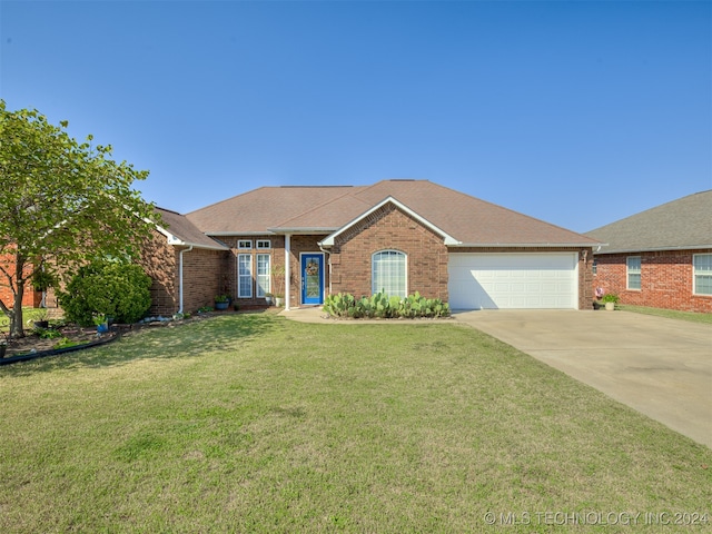 single story home featuring a garage and a front lawn