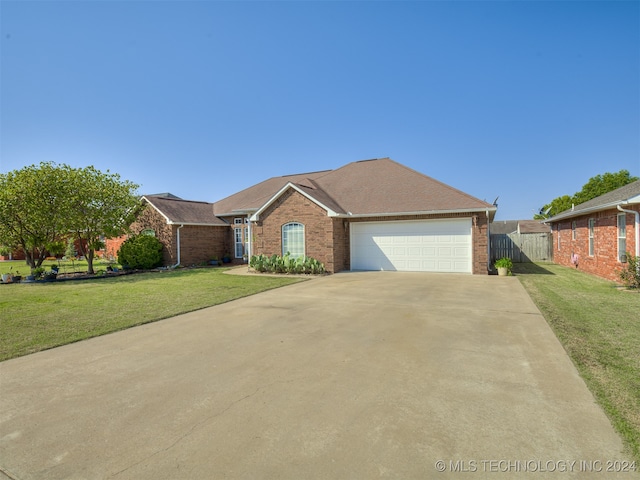 ranch-style house featuring a front yard and a garage