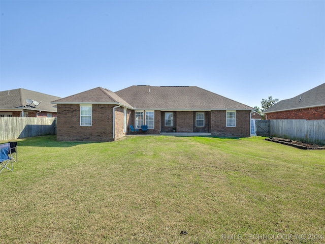 rear view of house featuring a lawn