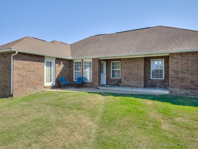 rear view of property with a yard and a patio area