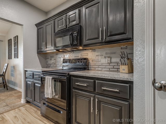 kitchen featuring black appliances, vaulted ceiling, backsplash, and light hardwood / wood-style flooring