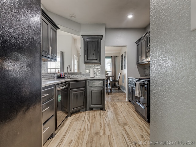 kitchen with black appliances, a wealth of natural light, sink, and light hardwood / wood-style flooring