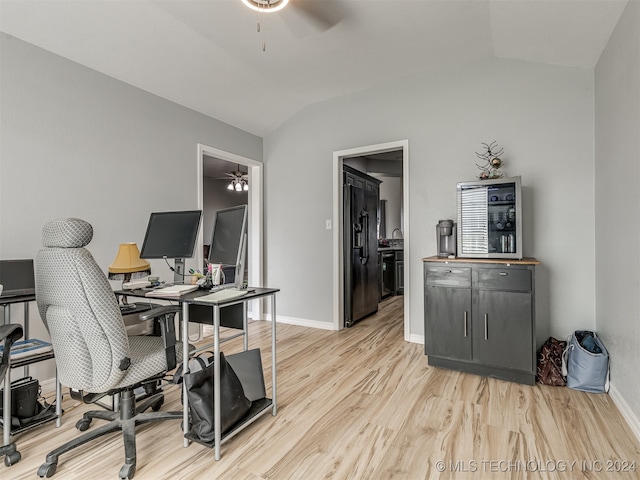 home office with ceiling fan, vaulted ceiling, and light hardwood / wood-style floors