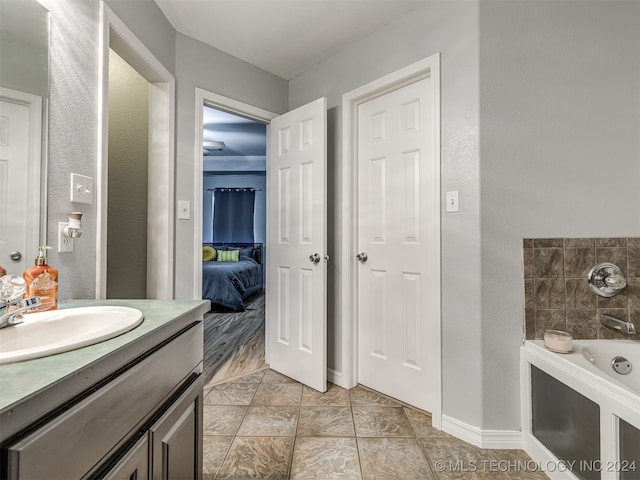 bathroom featuring tile patterned flooring, a washtub, and vanity