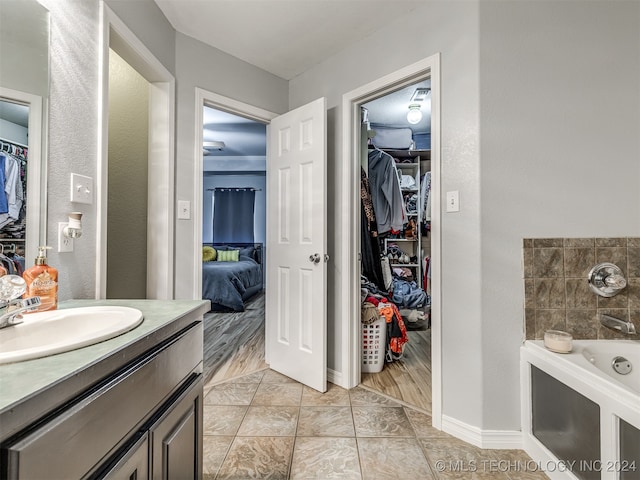 bathroom featuring vanity, a washtub, and hardwood / wood-style flooring