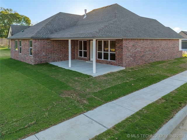 back of property featuring a yard and a patio area