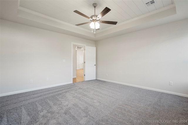 carpeted empty room with ceiling fan, a raised ceiling, and crown molding