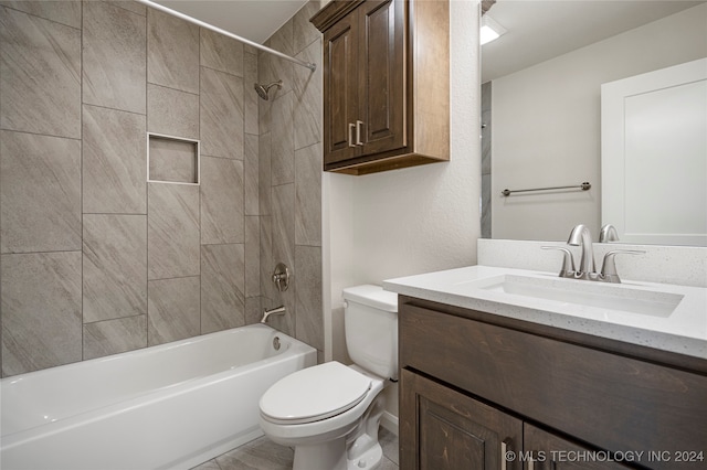 full bathroom featuring vanity, tiled shower / bath combo, and toilet