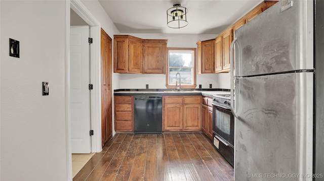 711 NW Elizabeth St, Ardmore, OK 73401 - kitchen with dishwasher, range, stainless steel fridge, dark hardwood / wood-style flooring, and sink