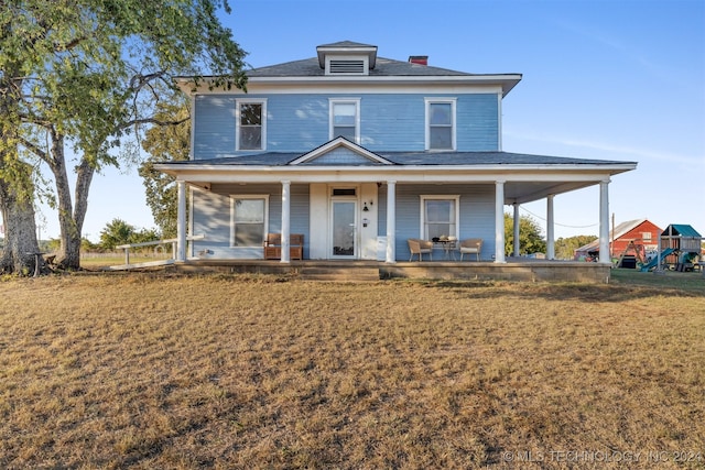 farmhouse with a front yard and a patio area