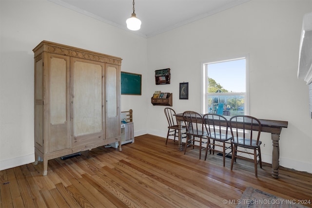 dining space featuring ornamental molding and light hardwood / wood-style flooring